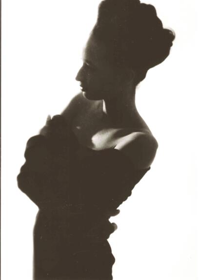 Silhouette of a woman with an elegant updo hairstyle, wearing a strapless top.