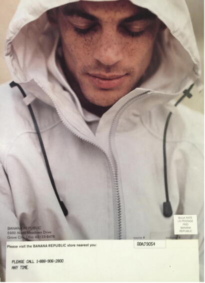 Close-up of a young man with tousled hair, wearing a white hooded jacket with zipper detail.