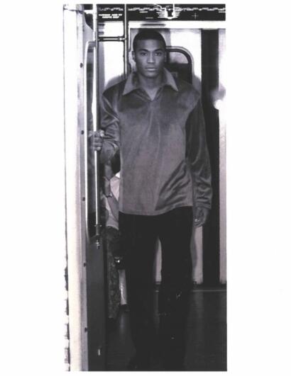 Stylish young man in a satin jacket exits a subway train, embodying modern urban fashion.