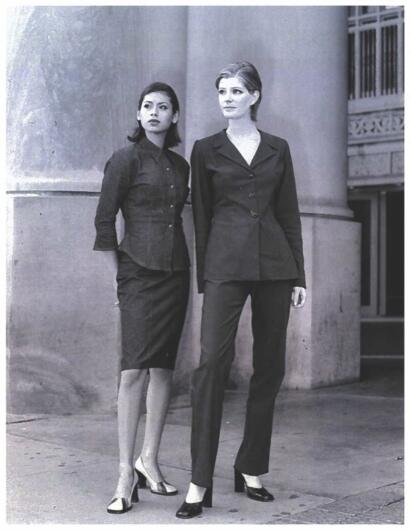 Two women in professional attire standing outside a building.