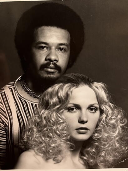 Black-and-white portrait of a man with an afro hairstyle and a woman with voluminous curly hair, both looking directly at the camera.