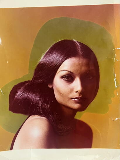 Close-up of a woman with sleek, dark hair styled in waves.