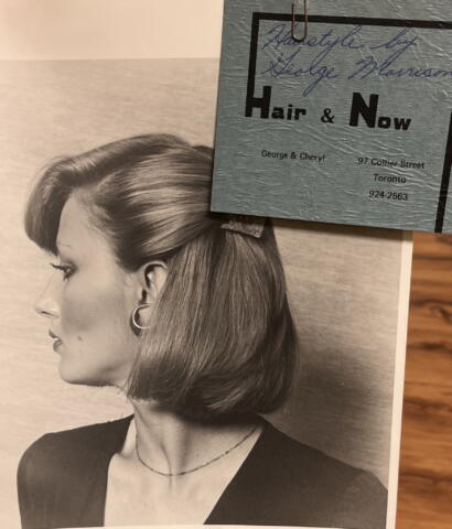 Black-and-white profile photo of a woman with styled hair, hoop earrings, and a necklace.
