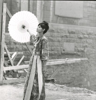 Woman in traditional Japanese kimono holding a parasol on a construction site.