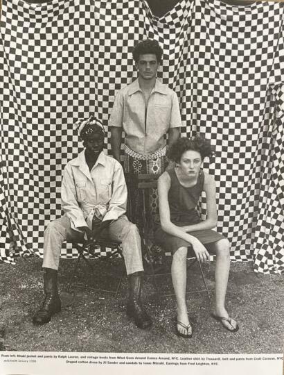 Group of three fashion models posing against a checkered backdrop, showcasing eclectic styles.