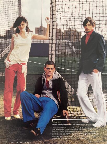 Group of three stylish young adults dressed in sporty casualwear outdoors on a rooftop tennis court.