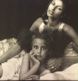 Black-and-white portrait of two women, one resting her head on the other's shoulder.