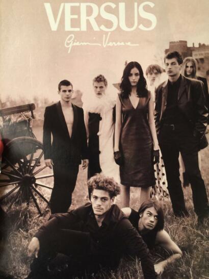 A group of young adults dressed in edgy, high-fashion outfits pose outdoors in a staged, dramatic scene.