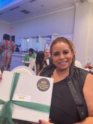 Woman holding a certificate at an event honoring accomplished Black Canadian women.