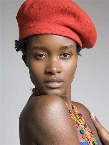Portrait of a woman wearing a red beret and colorful beaded jewelry.
