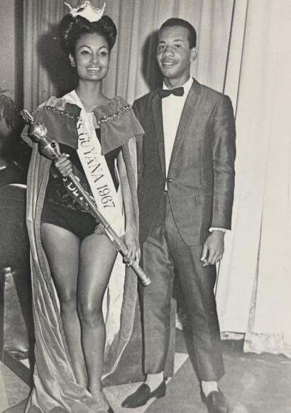 Miss Universe 1967 wearing her sash and crown, with a man in formal suit.