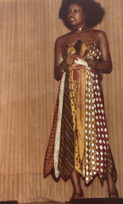 Woman wearing a colorful patchwork dress with African prints and patterns.