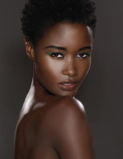 Close-up portrait of a woman with natural hair and vibrant eye makeup.