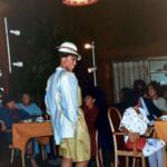 Fashionable woman in vintage-inspired outfit posing in a cozy indoor restaurant setting.